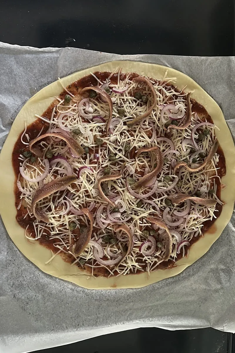 Anchovy caper pizza preparation