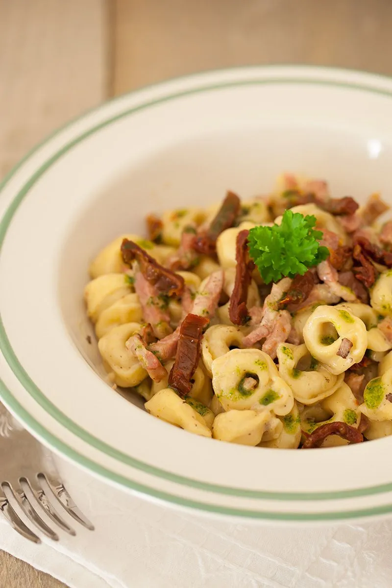 Cheese tortellini with bacon and herb oil