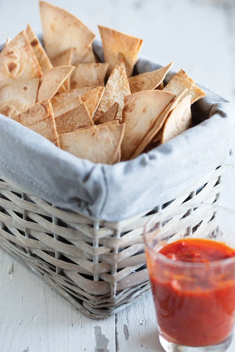 Homemade tortilla chips with red chilli dipping sauce