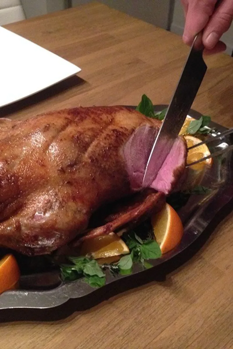 Slicing a roasted whole duck