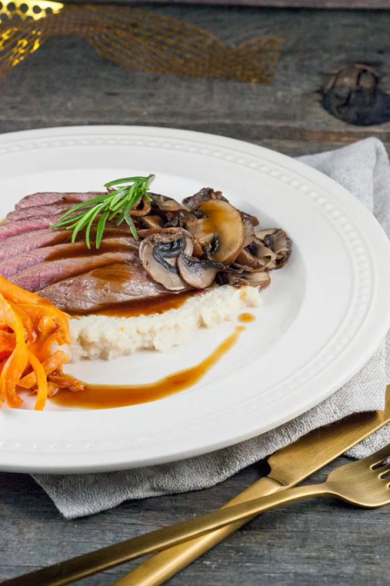 Venison steak with roasted cauliflower puree and sweet potato fries