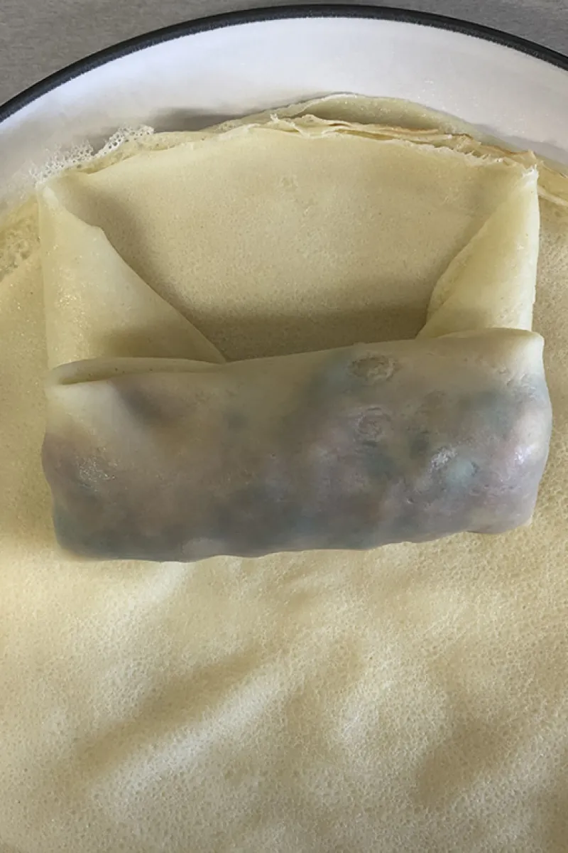 Folding the ham and chicken lumpia