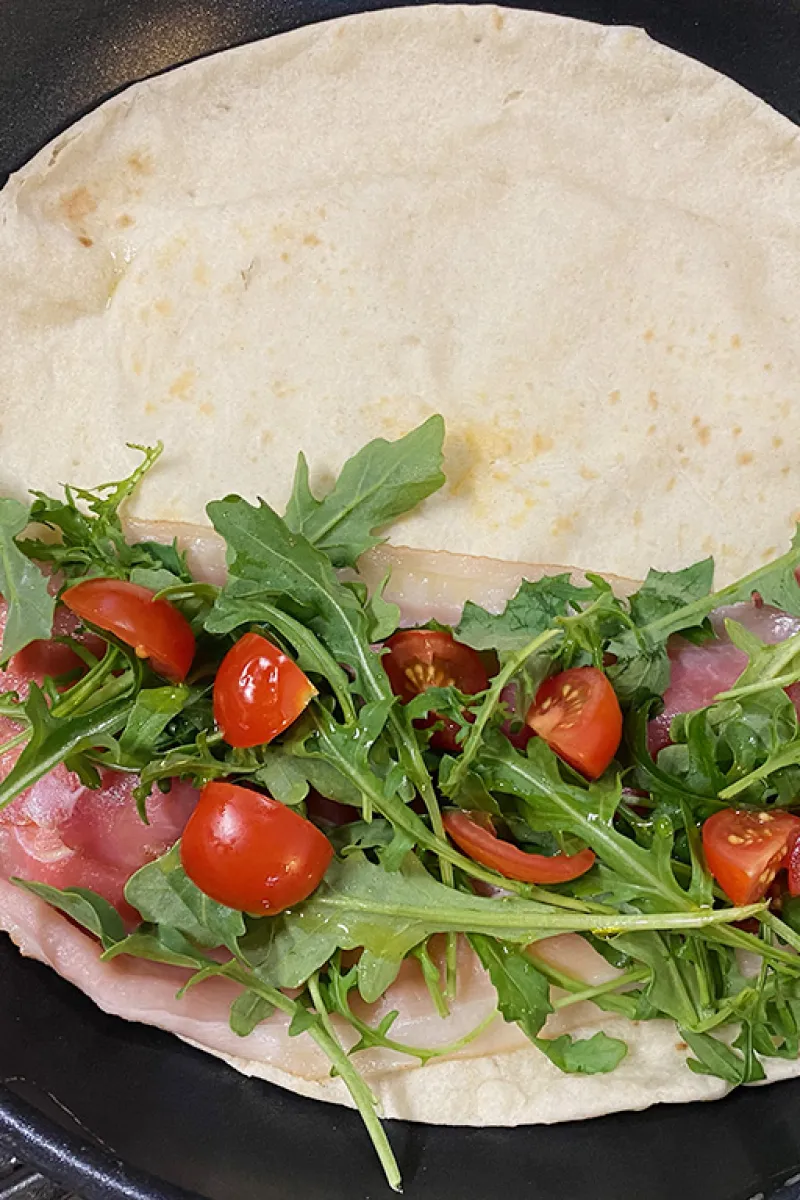 Preparing the Piadina with ham and mozzarella