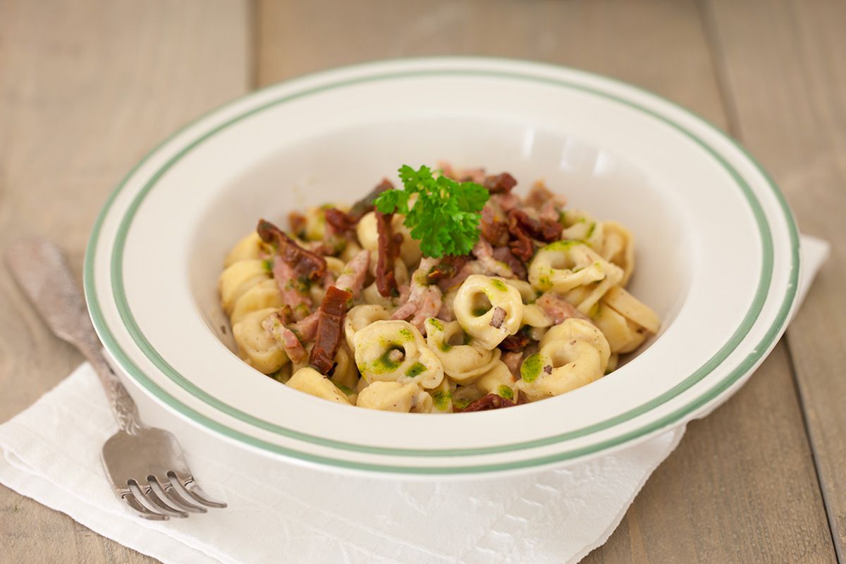 Cheese tortellini with bacon and herb oil