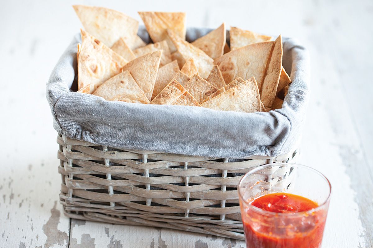 Homemade tortilla chips with red chilli dipping sauce