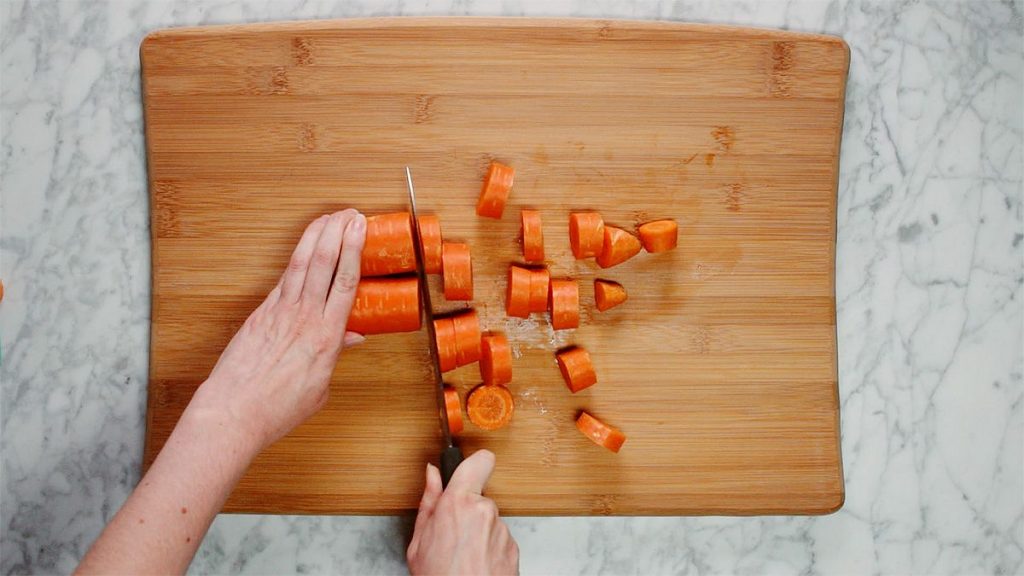 Comforting beef bone broth cutting carrot