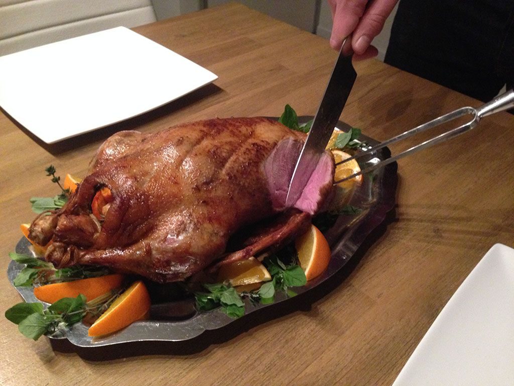 Slicing a roasted whole duck