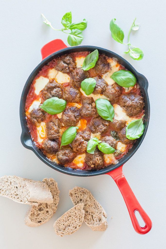 Oven baked meatballs in tomato sauce and mozzarella